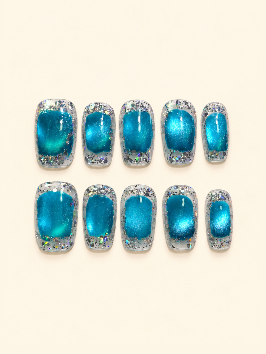 OVANA electric blue cat-eye press-on nails framed by silver holographic glitter