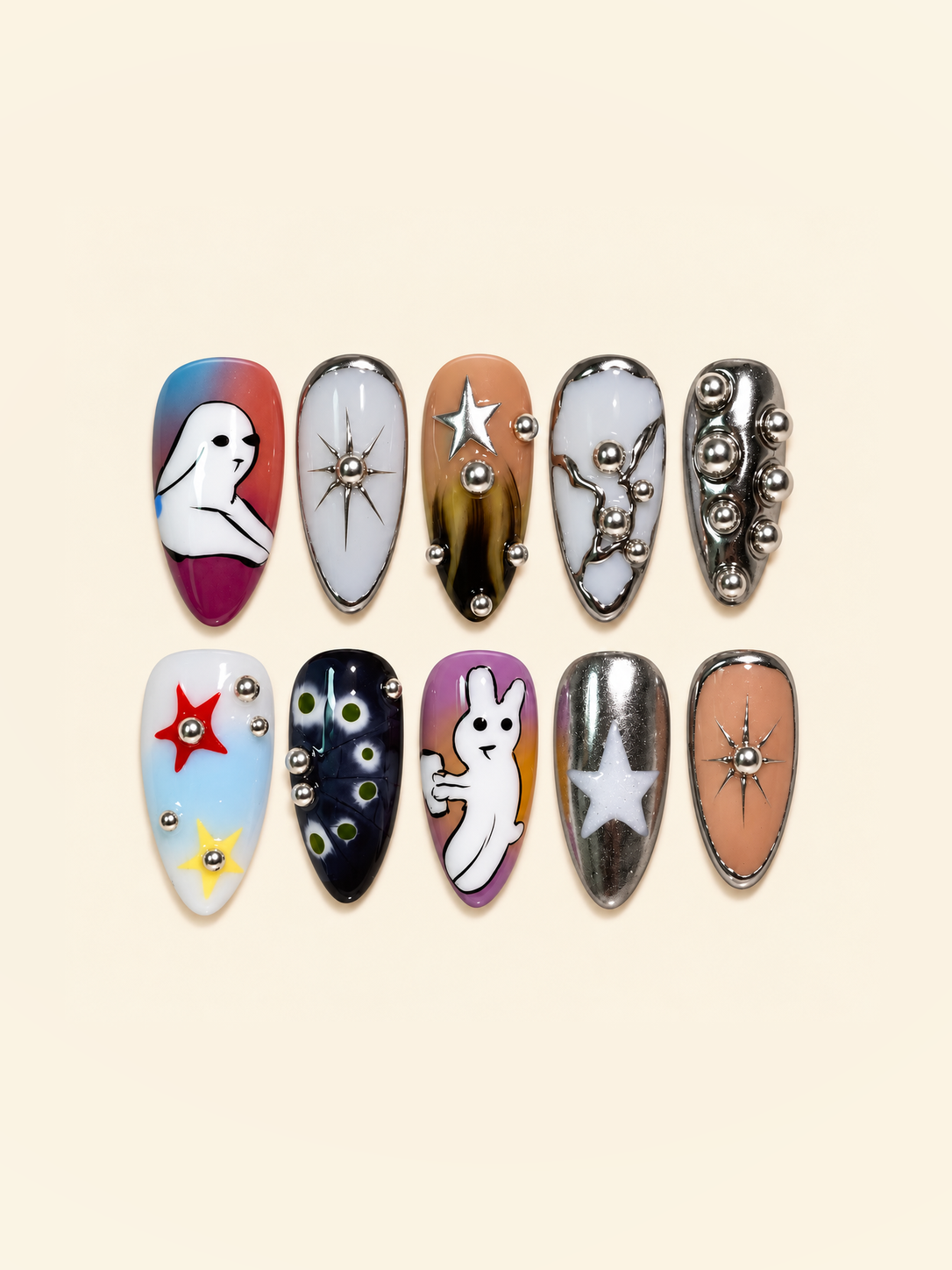 OVANA Halloween press-on nails with white ghosts, silver chrome stars, metallic beads, and colorful accents