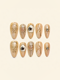 OVANA peach-gold Halloween press-on nails with sculpted skull, eye, heart, and star motifs