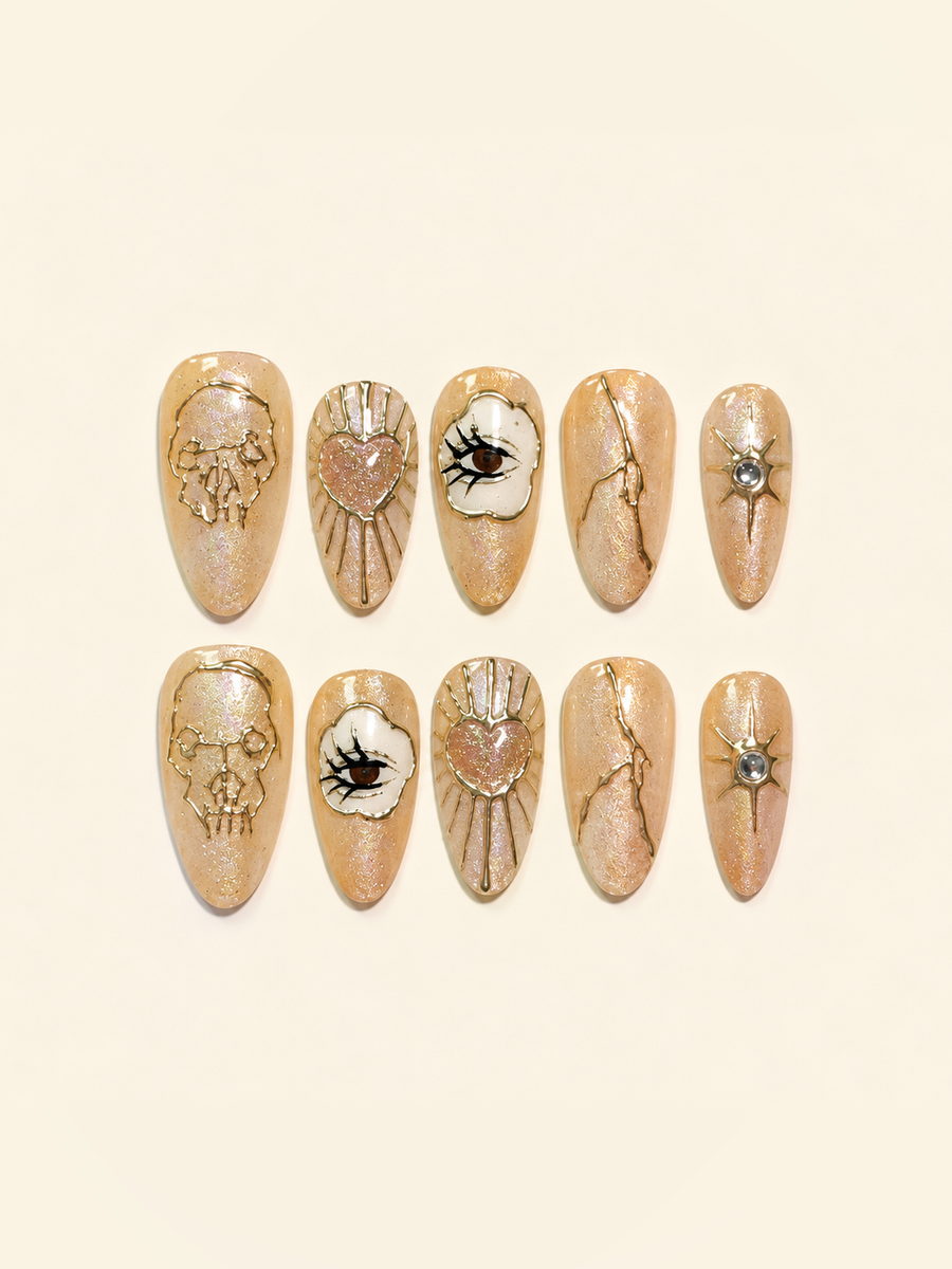 OVANA peach-gold Halloween press-on nails with sculpted skull, eye, heart, and star motifs