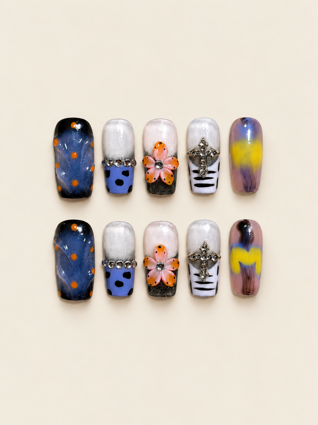 Ten glossy square press-on nails with raised peach-and-orange flowers, blue nails with orange dots, jeweled crosses, and violet-yellow swirls