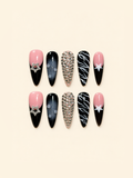 Ten pointed pink and black press-on nails with star accents, rhinestones, smoky ombré, raised droplets, and white swirls