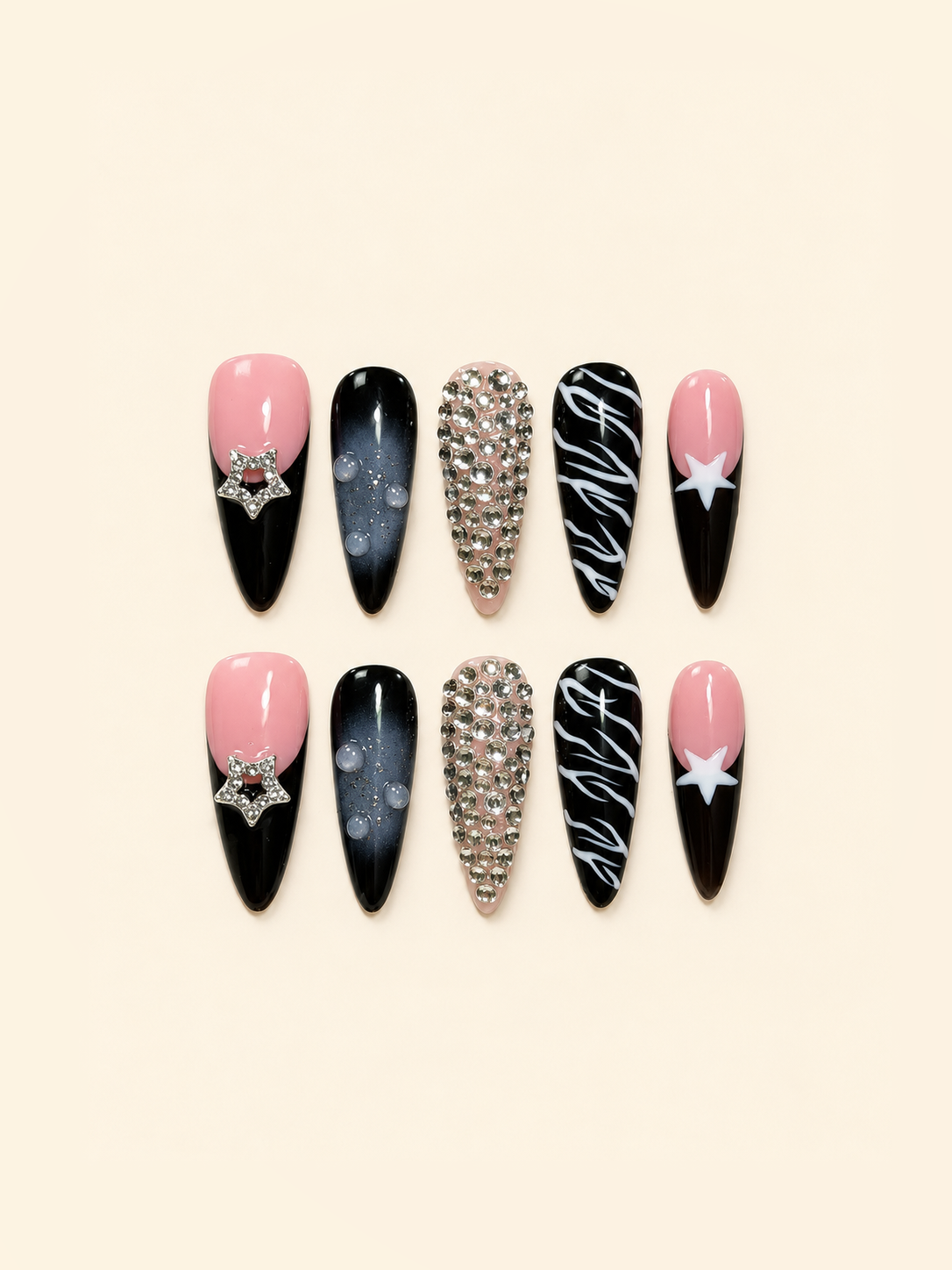 Ten pointed pink and black press-on nails with star accents, rhinestones, smoky ombré, raised droplets, and white swirls