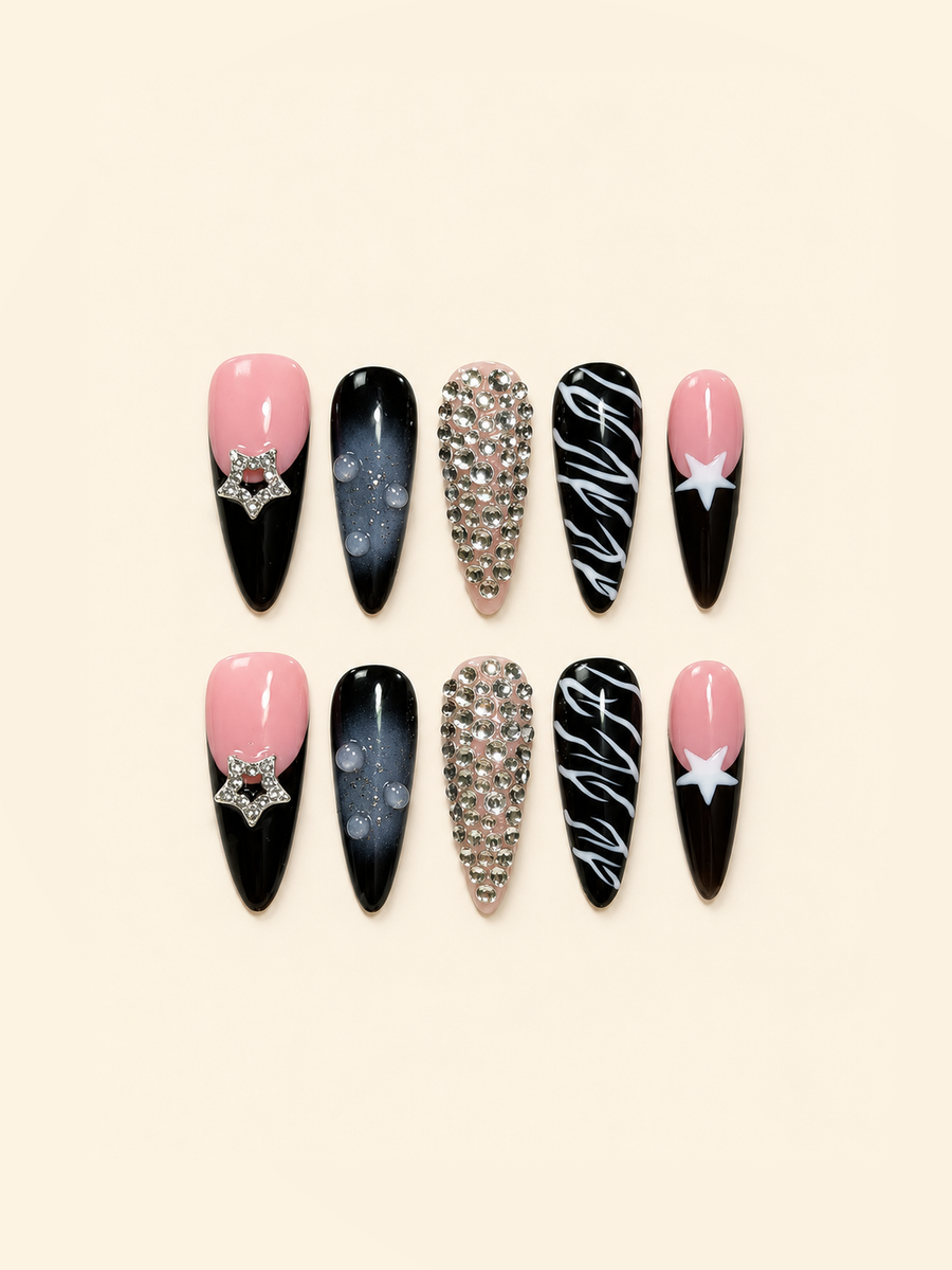 Ten pointed pink and black press-on nails with star accents, rhinestones, smoky ombré, raised droplets, and white swirls