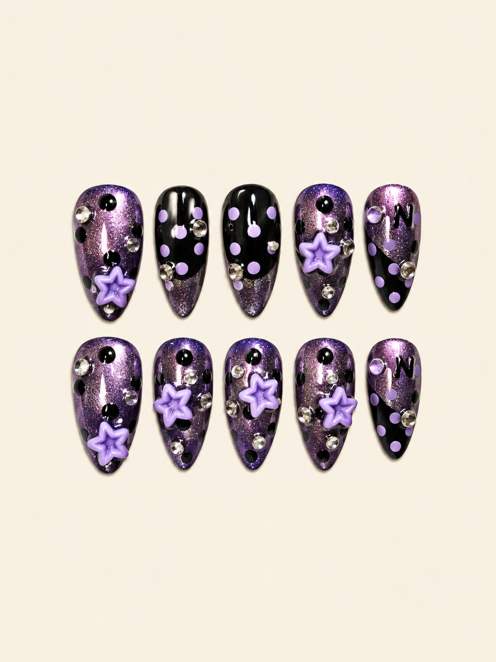 OVANA purple shimmer and black press-on nails with lavender polka dots, 3D stars, and crystal accents